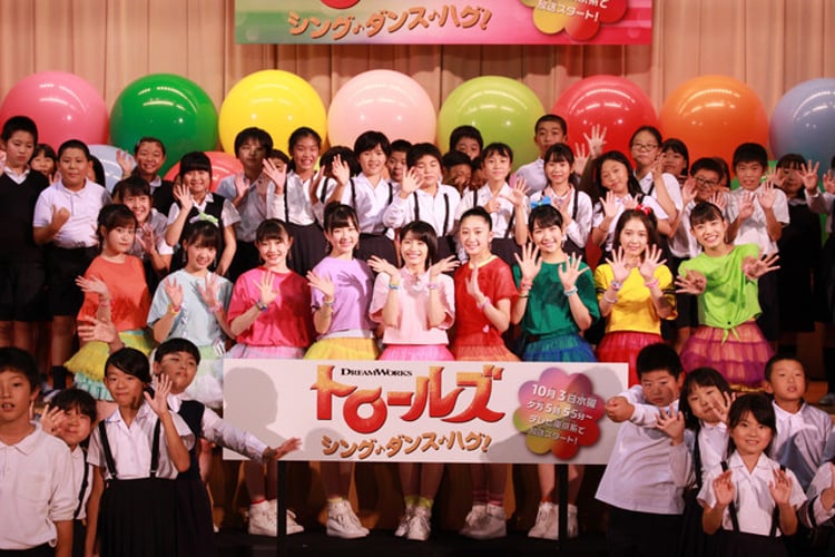 9月に行われた「トロールズ：シング・ダンス・ハグ！」テーマ曲お披露目イベントの様子。東京・東泉小学校の児童たちと記念撮影するつばきファクトリー。