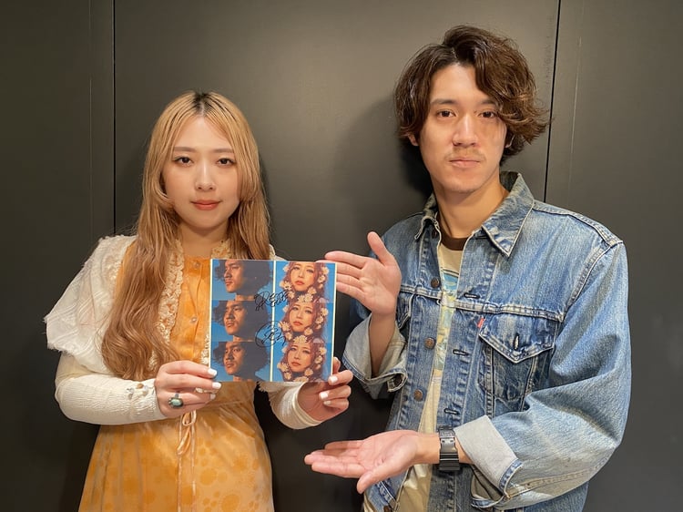 直筆サイン入りフォトカードをアピールするGLIM SPANKY。